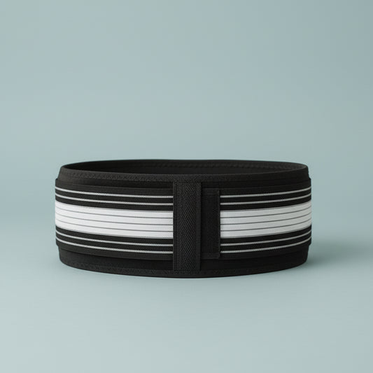 Black and white waist belt on a light surface with a blurred background